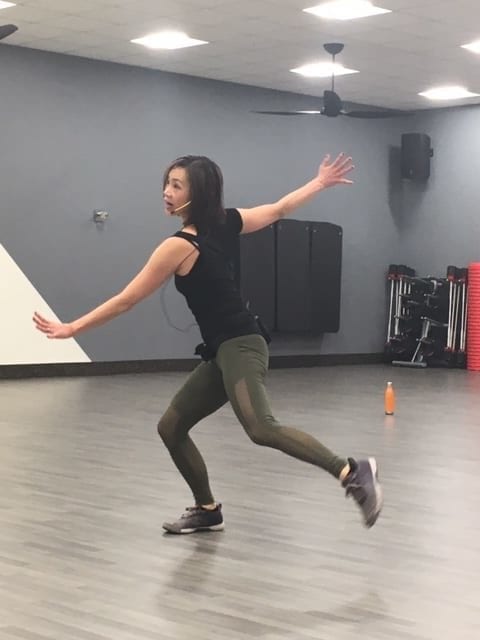 LaBlast instructor Vivien Chilton teaching a class in green leggings and a black shirt
