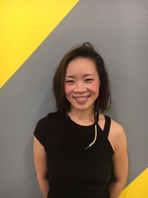 Chuze Fitness Instructor Vivien Chilton headshot in a black shirt with gray and yellow background