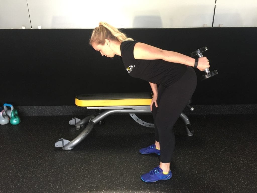 Personal trainer tricep kickbacks on leg
